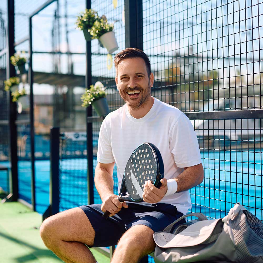 happy-paddle-tennis-player-on-an-outdoor-court-loo-MX89ERL.jpg